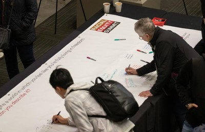 People signing the Freedom Dreaming banner.