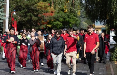 A group of people in red shirts walking down a street.