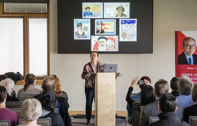 Florence Hsia delivering lecture in front of screen.