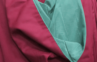 Close-up of green and claret academic robes