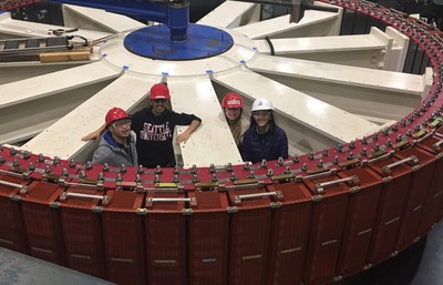 Students in safety gear standing inside a shut down hydro turbine