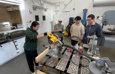 Mechanical Engineering students using a miter saw in the machine shop