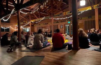 Students seated on the ground in a cabin