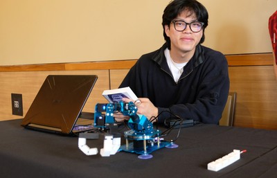 A student holding a copy of Binti and showcasing a soft robotics model.
