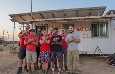 Seattle University students and recent graduates celebrate the opening of the solar powered energy kiosk in Chalokwa, Zambia.