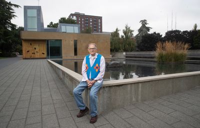 Father Twohy sitting in front of the chapel