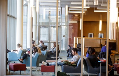 A group of people sitting in a library.