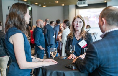 Professionals engaging in a networking event with drinks.