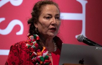Professor Gabriella Gutiérrez y Muhs speaking on a stage.