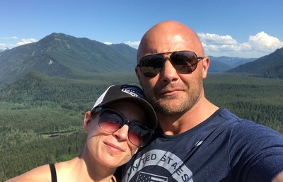 Two people taking a selfie with a view of mountains in the background