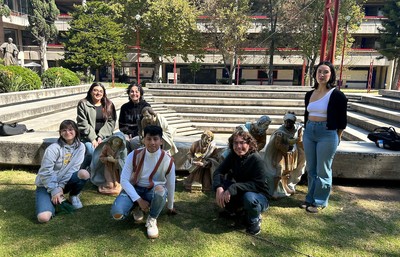 SU Students posing by small statues