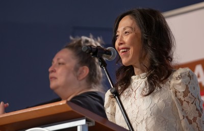 Professor Sharon Suh smiling and speaking into a microphone