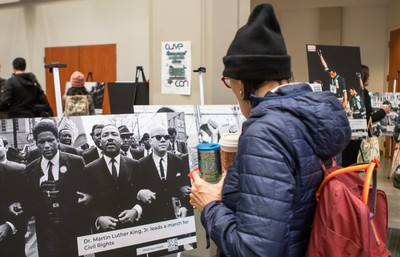 A person looking at a picture of Martin Luther King and others at a civil rights march.