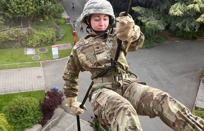 Cadet rappels down a building on campus