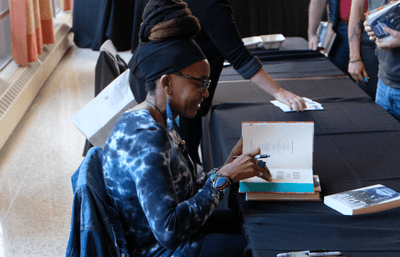 Doctor Nnedi Okorafor signing a book.