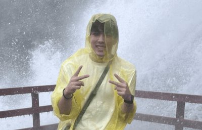 Person in poncho at a waterfall