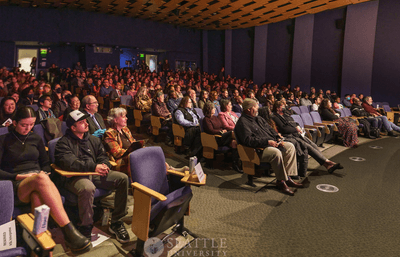 An audience in an auditorium looking at the stage.