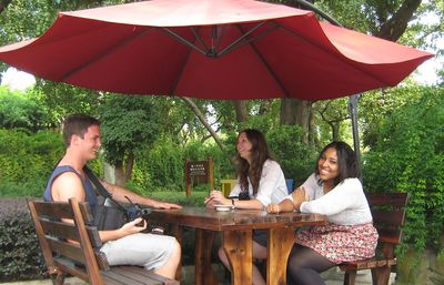 Three minor Chinese students hanging out in a garden