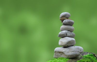 Stack of grey stones against a lush green background