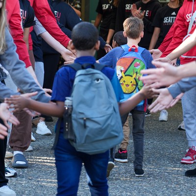 A group of people standing around a group of children.