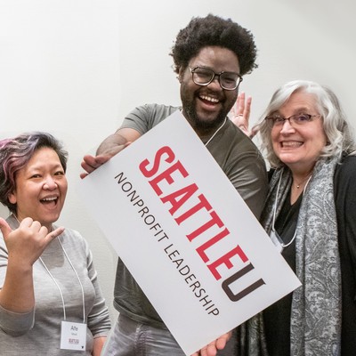 A student holding an SU nonprofit leadership sign