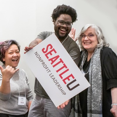 A student holding an SU nonprofit leadership sign