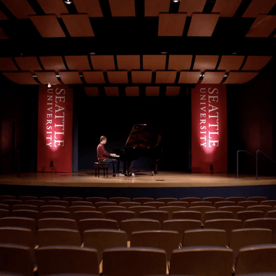 student playing a piano on stage