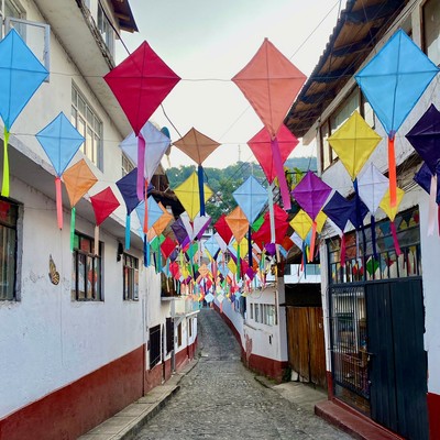 Street in Mexico with colorful kites suspended above