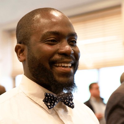 A man smiling in a bow tie.