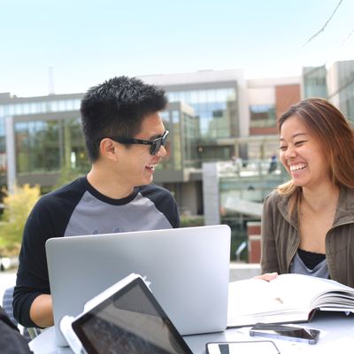 Two students sitting and talking outside library