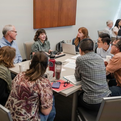 A group of eight Provost Fellows in discussion at a table