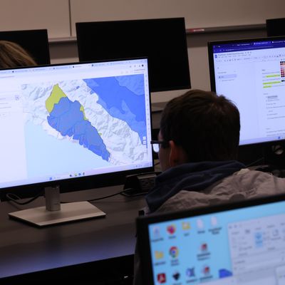 Student sitting in front of computer with map pulled up
