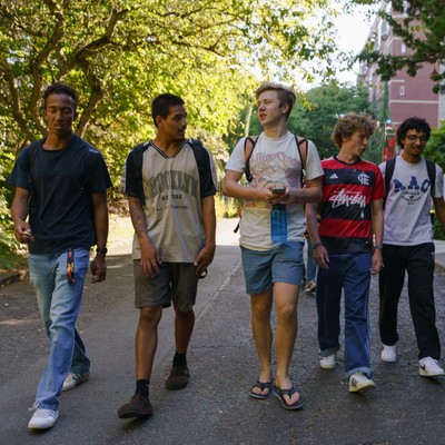 6 students walking outdoors on-campus