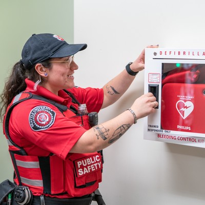 DPS officer opening an AED cabinet.