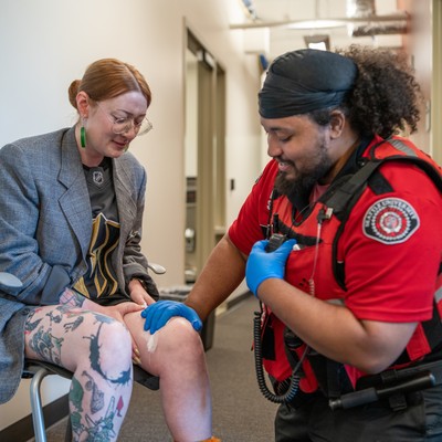 DPS officer applying pressure to a wound on the leg of a woman