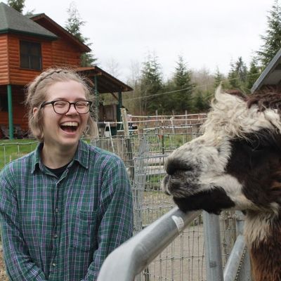 Student Madison Piper posing with a llama