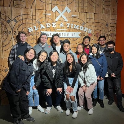 A group of students posing underneath the Blade and Timber logo