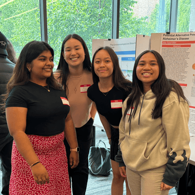 Four Students in Front of Poster