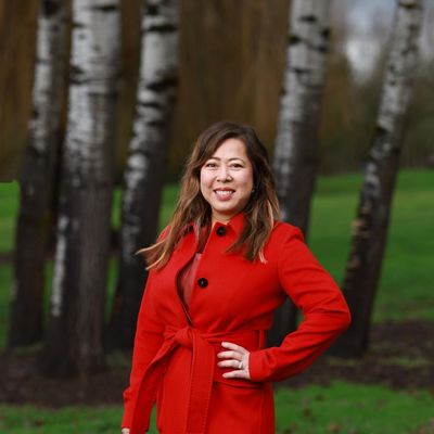 Madeline Haydon standing in front of trees in red coat