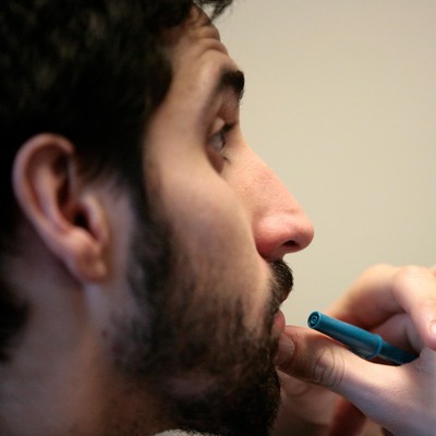 A man with a beard and mustache holding a pen.