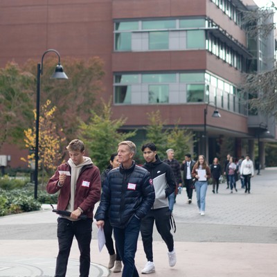 A student and parent walk along the lower mall on campus