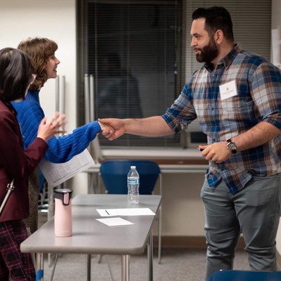 A man shaking hands with another man.