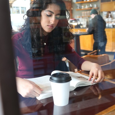 A woman reading a book at a table.