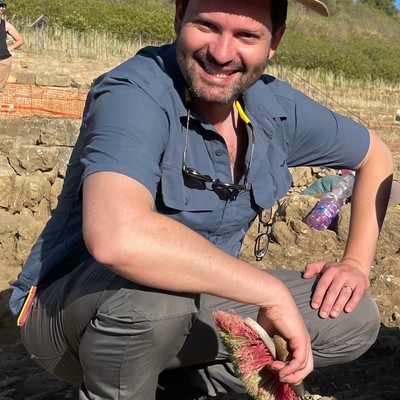 a man in a field holding a tool