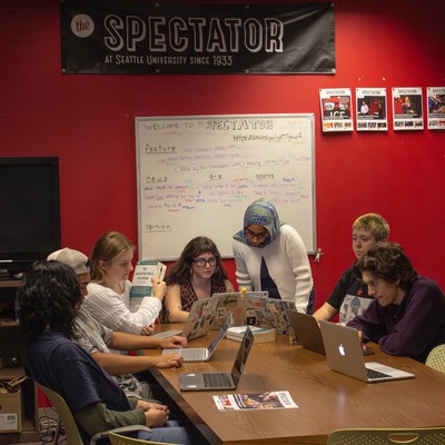 a group of journalism students working in a newsroom