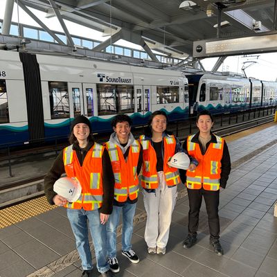 Student team in safety gear standing in front of Sound Transit Link Light Rail train