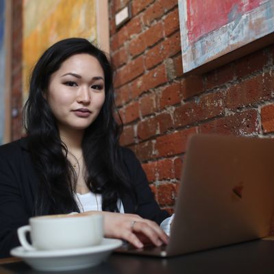 Student completing coursework at a coffee shop