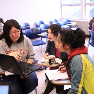 Three students discuss a class project