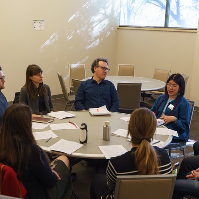 Faculty and staff sitting in a circle, talking