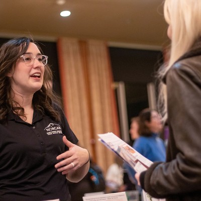 Two women talk at an event